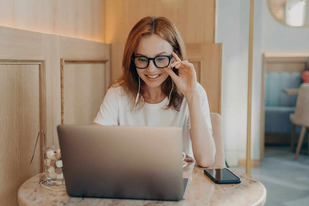 Woman remote worker looks in laptop screen